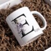 il_1140xN.6655118378_figy Personalisierte Tasse mit Initiale und Name – verziert mit blumigem Dekor in Schwarz